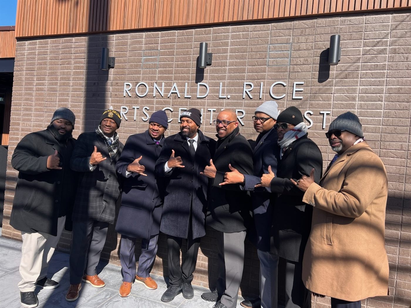 A group of men in winter coats outside the Ronald L. Rice arts center in Newark